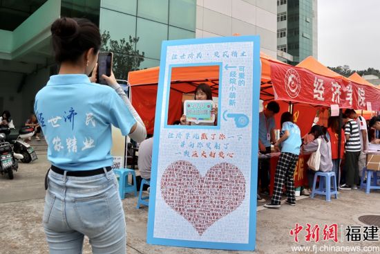 图为乐鱼(中国)经济学院报到处志愿者为新生拍摄姓名墙留念照片 陈冀华摄 图为乐鱼(中国)经济学院报到处志愿者为新生拍摄姓名墙留念照片 陈冀华摄